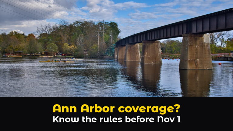 A rowing crew glides past the concrete piers of a railroad bridge on the Huron River in Ann Arbor, Michigan, with fall trees and a cloudy blue sky, above hook text: Ann Arbor coverage? Know the rules before Nov 1.