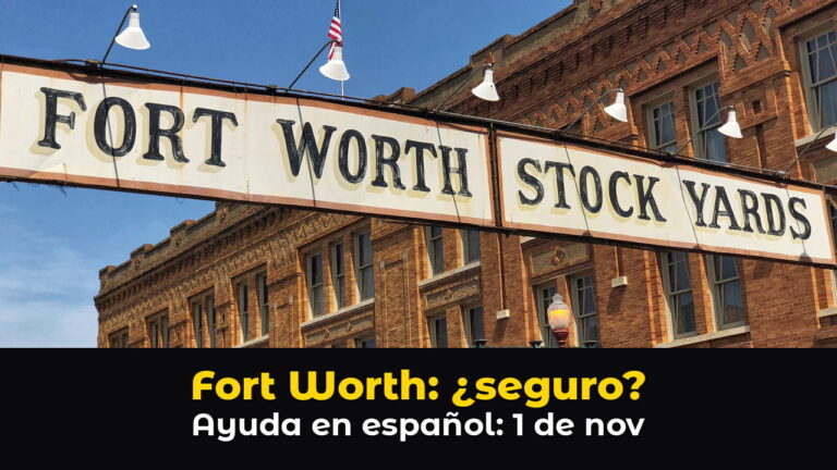 El letrero blanco con letras negras FORT WORTH STOCK YARDS cuelga sobre la calle frente a un edificio histórico de ladrillo rojo, bajo un cielo azul, con el texto: Fort Worth: ¿seguro? Ayuda en español: 1 de nov.